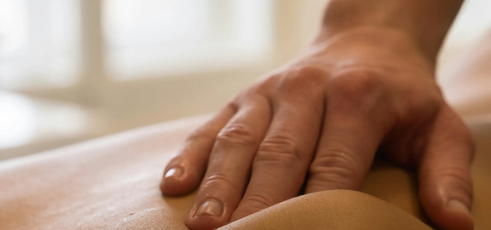 Close-up of hands applying firm pressure during a deep tissue technique