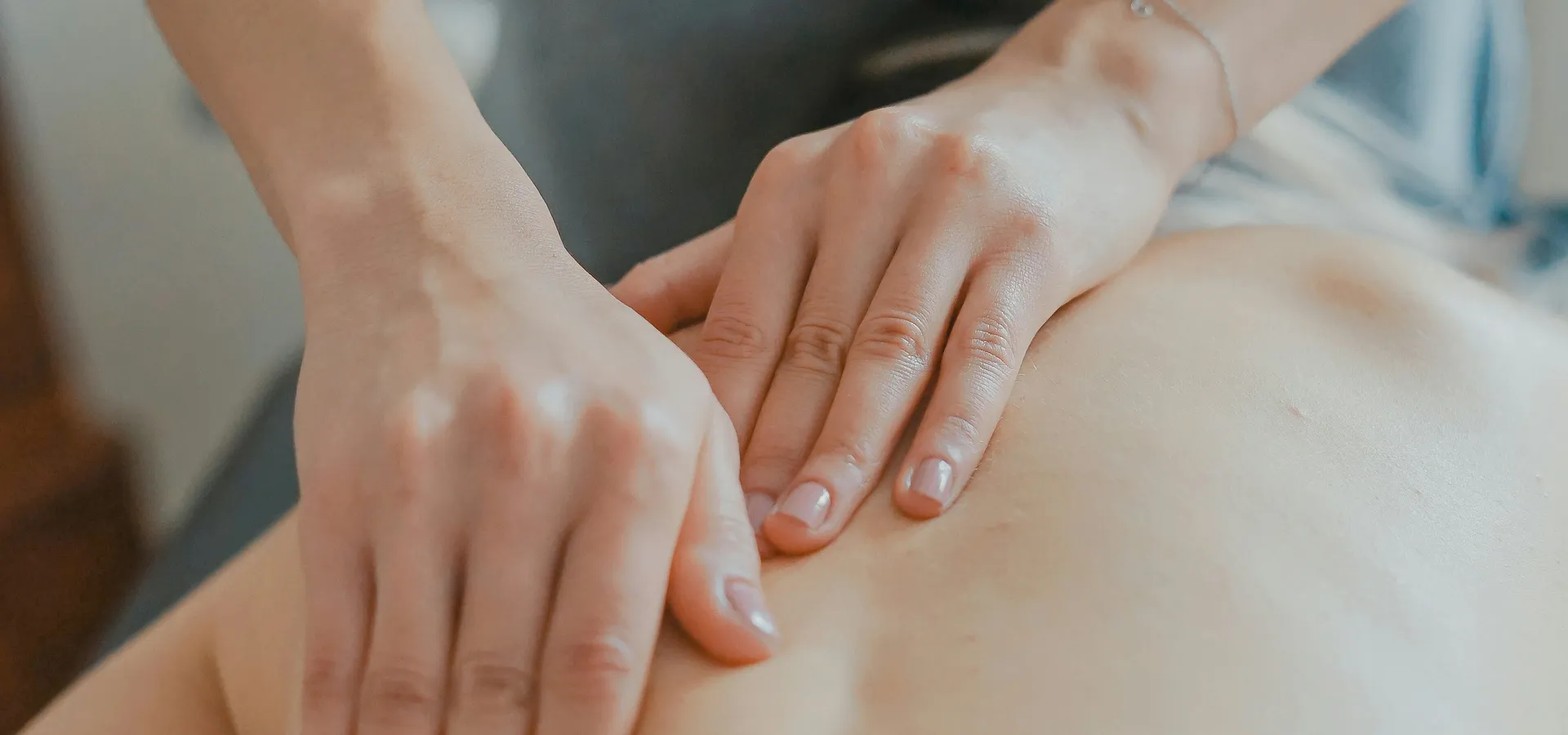 A therapist working on a client's shoulder during a treatment session
