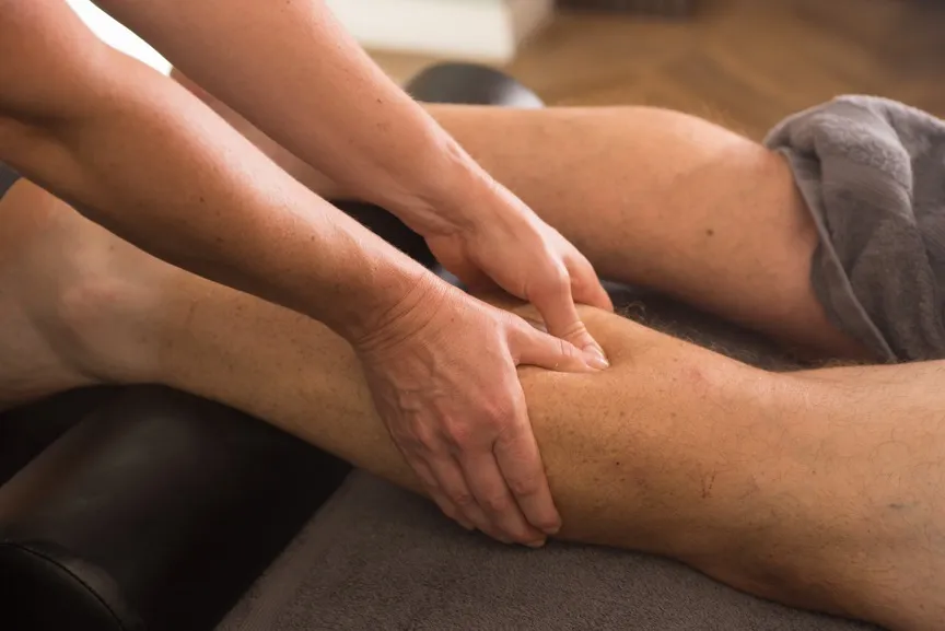 Firm thumb and hand pressure applied to a client's calf during a deep tissue technique